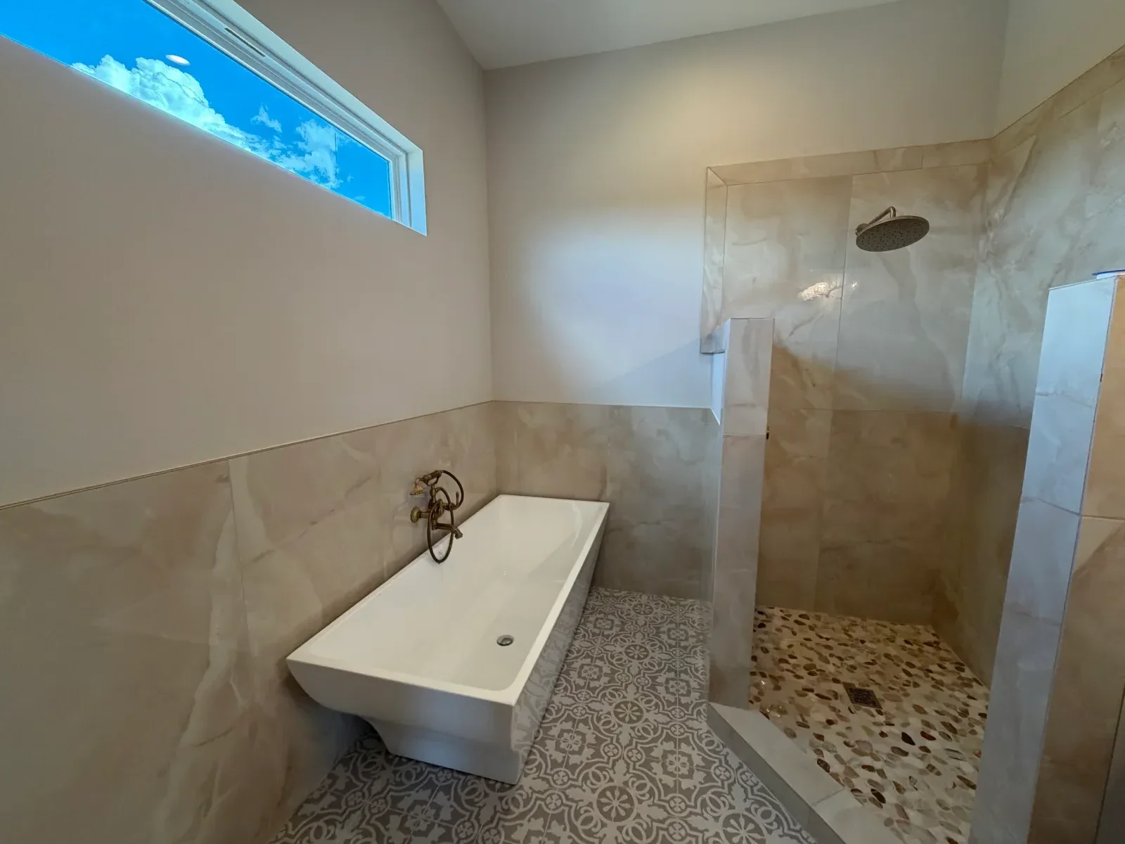 Walk-in shower with frameless glass door, ceramic tile walls, and patterned ceiling detail